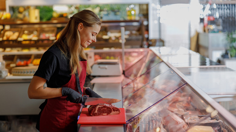 A butcher slices a piece of steak