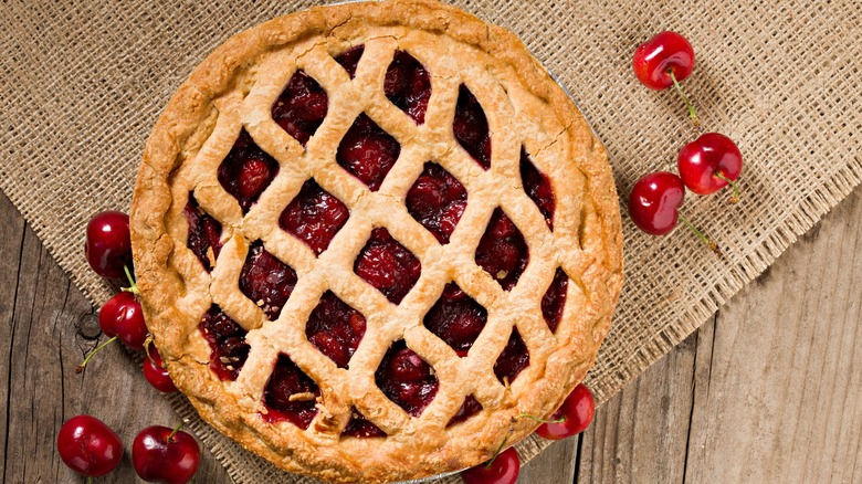 Cherry pie on burlap with cherries