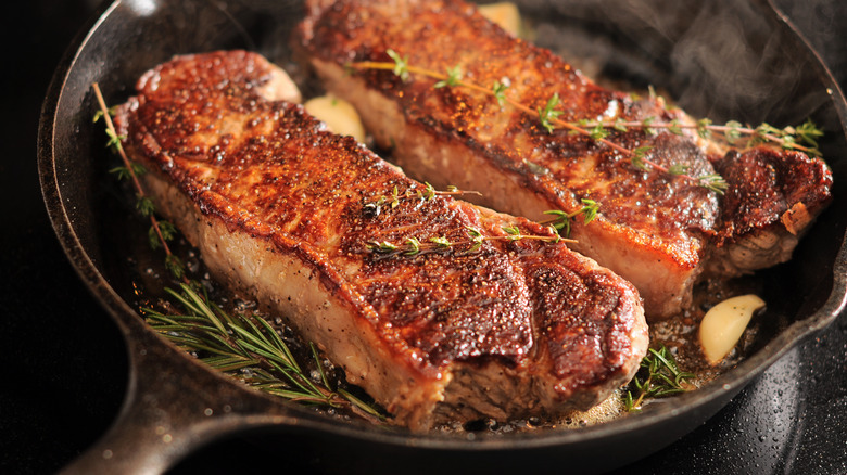 Steak cooking in cast iron pan