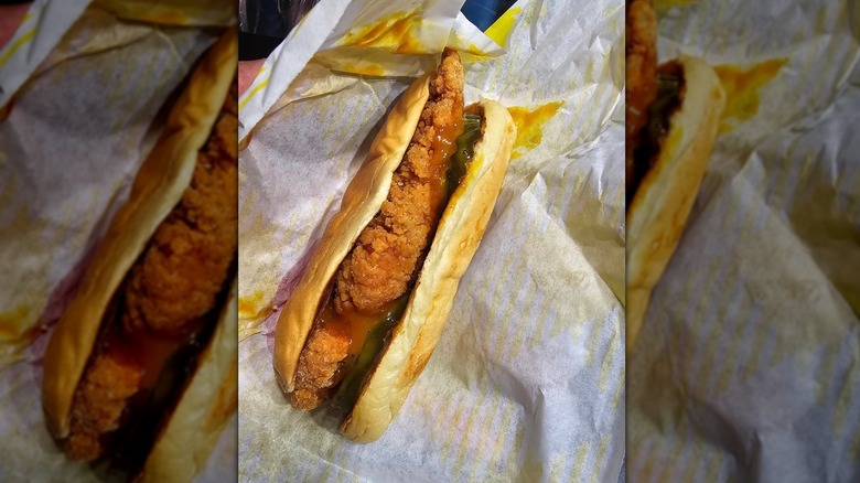 Fried chicken tender with on a hot dog bun drenched with honey mustard