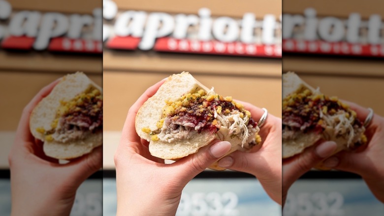 Bobbie sandwich with turkey, stuffing, and cranberry held in front of Capriotti's