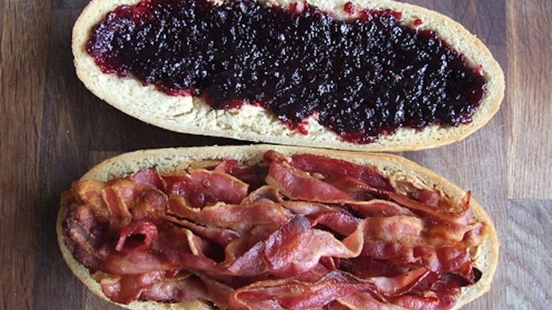 Two halves of a loaf of bread filled with jam, peanut butter, and bacon