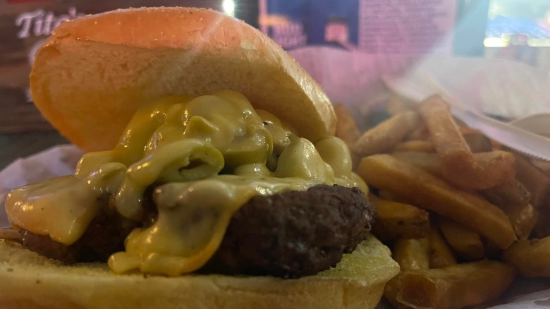 Burger topped with olive spread served with French fries