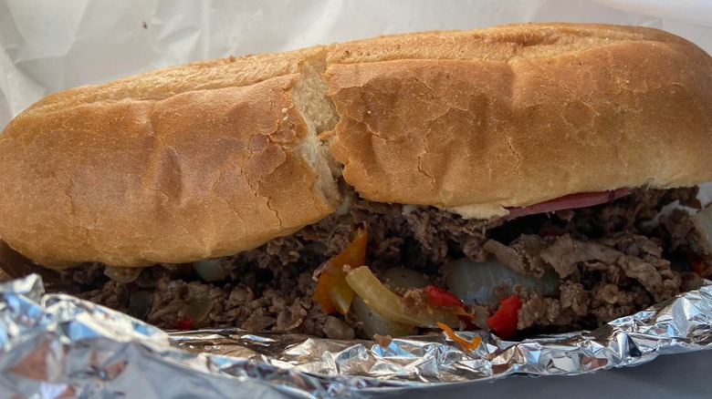 Shaved steak with onions and peppers on a sandwich roll in foil