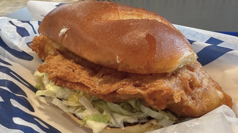 Crispy fried walleye on a bun with shredded lettuce in a basket