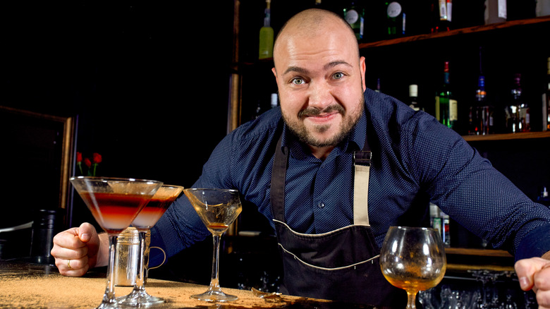 A bartender stands frustrated behind the bar