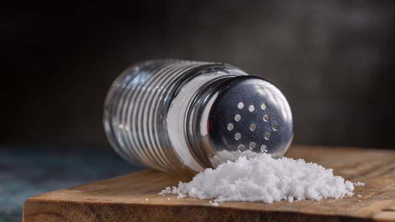 Salt shaker on its side with clump of salt