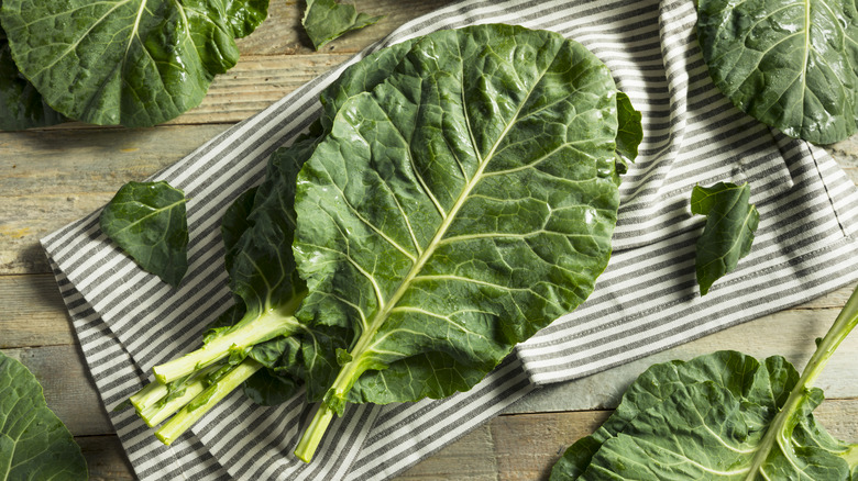 Large leaf collard greens on striped kitchen towel 