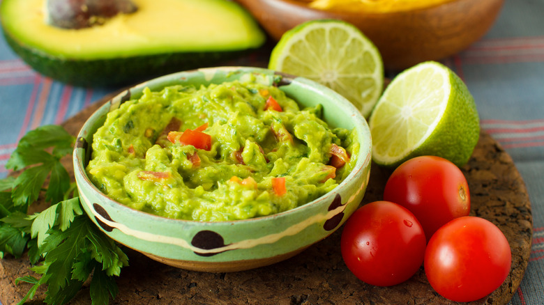 Bowl of guacamole surrounded by ingredients