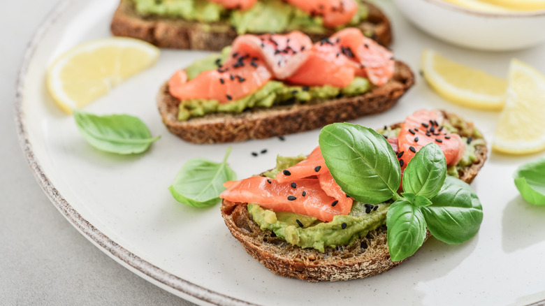 Guacamole toast topped with salmon and basil