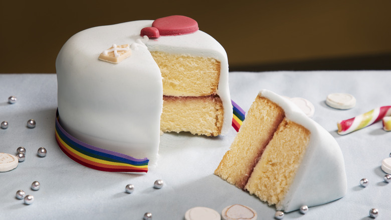 Whole cake with piece cut out of it on table