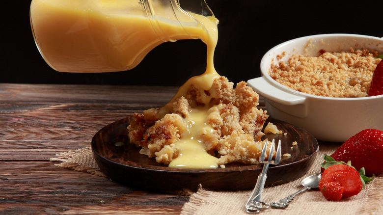 Custard pouring over crumbly cake on plate