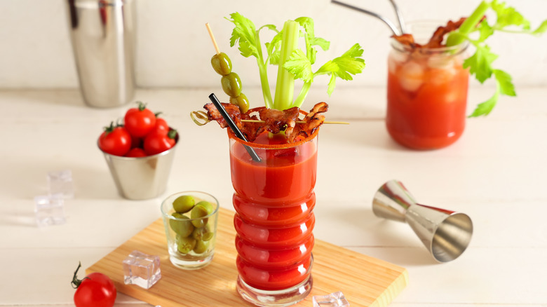 A bloody Mary surrounded by its ingredients