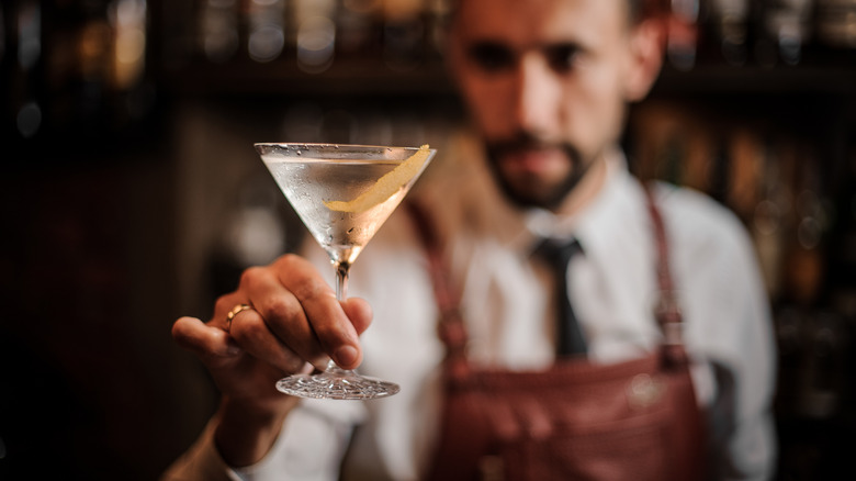 A bartender holding a martini glass.
