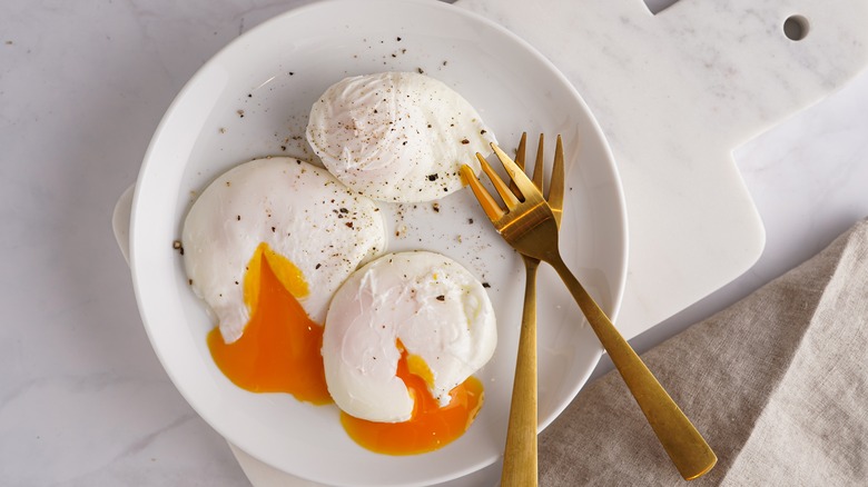 Three poached eggs cracked on plate