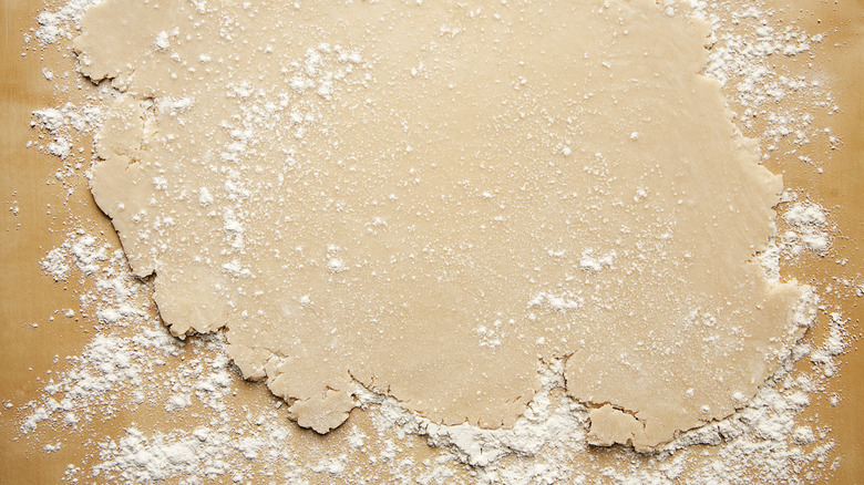 Dough rolled out flat on a floured work surface
