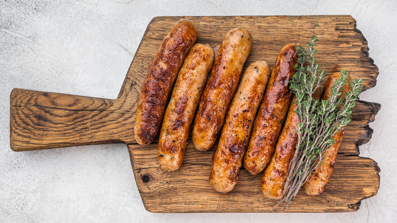 Grilled bratwurst served on a cutting board.