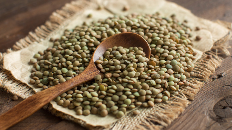 green lentils on a table with a wooden spoon