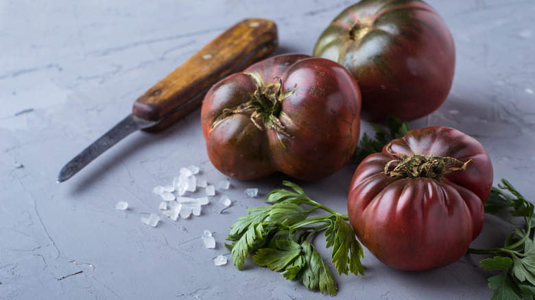 dark purple tomatoes on a grey surface