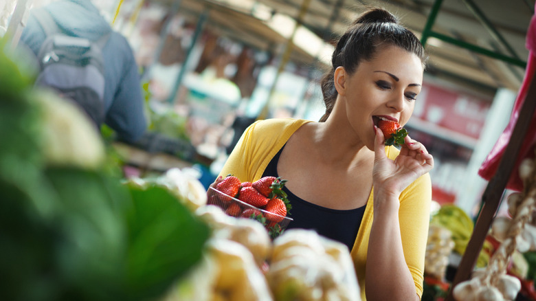 Grocery shopper eating strawberry