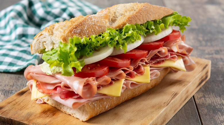 Sub sandwich with ham, cheese, tomatoes, onions, and lettuce