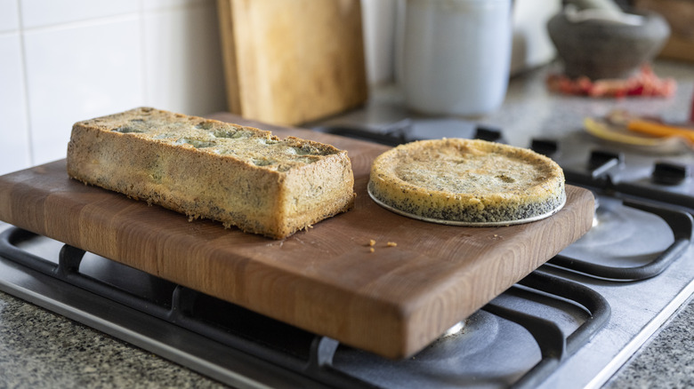 Cutting board with various foods resting on stovetop