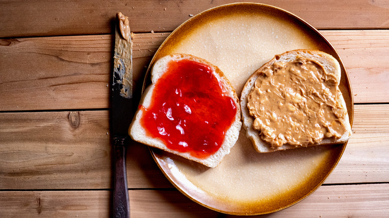 slices of jelly topped bread and peanut butter bread on place