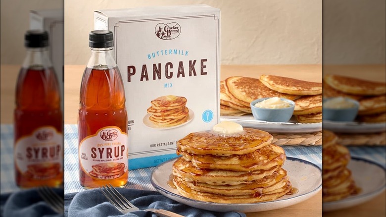 A stack of pancakes alongside Cracker Barrel's buttermilk pancake mix.