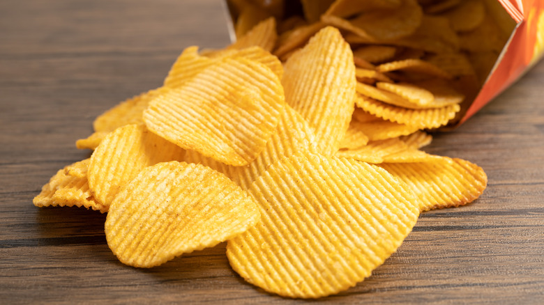 Potato chips spill out of bag onto table