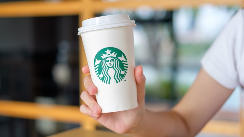 Person holding a cup of Starbucks