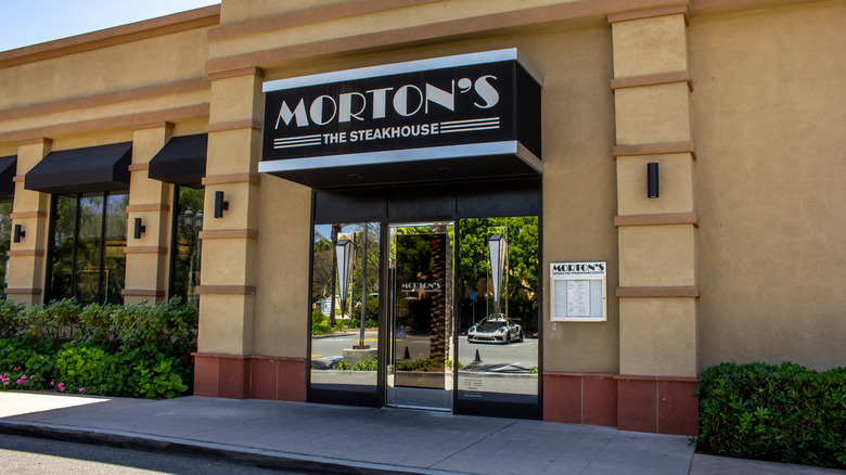 Entrance facade of Morton's The Steakhouse with its black and white logo sign and yellow-cream outside walls