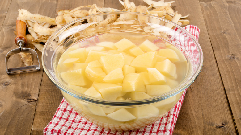 peeled diced potatoes soaking in bowl of water