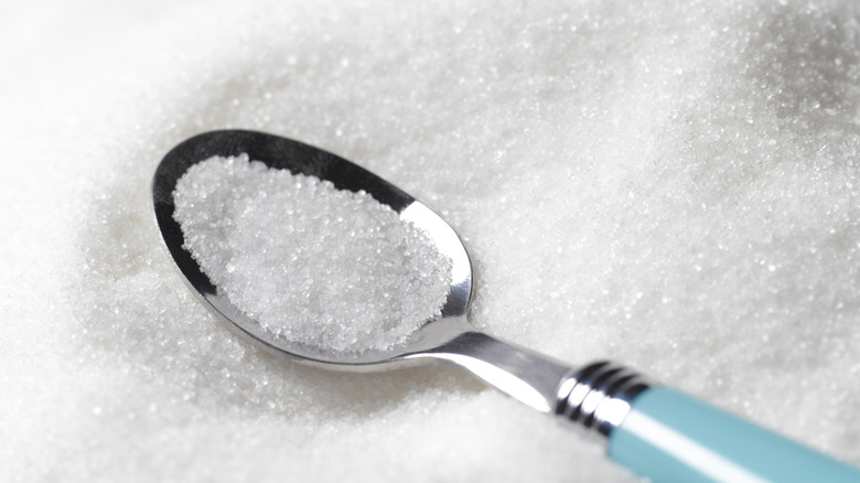 A spoon in a bed of white sugar