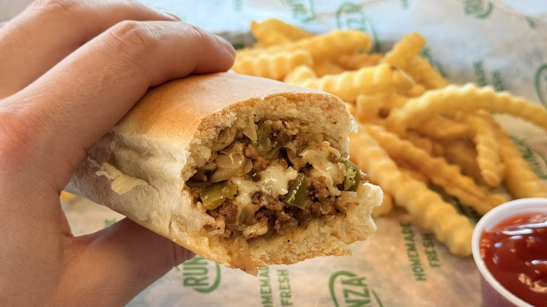 A hand holds a Runza sandwich.