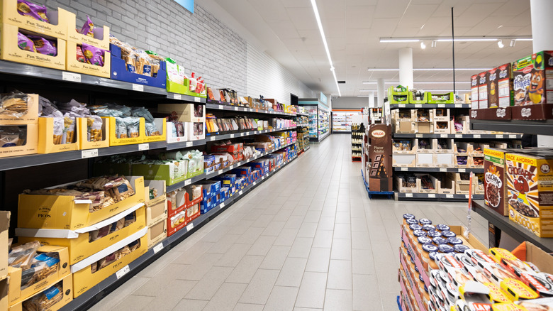 A grocery store aisle is filled with snacks on its shelves