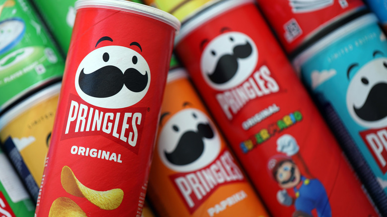 Different flavor Pringles can laying on their sides with a red Original flavor can on top