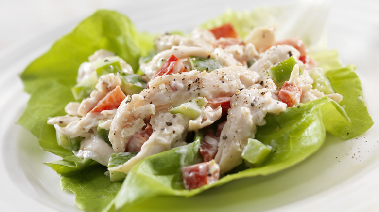 Chicken salad in a leafy base on a white background