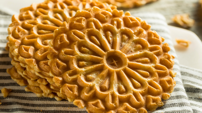 A stack of pizzelle on a kitchen towel.
