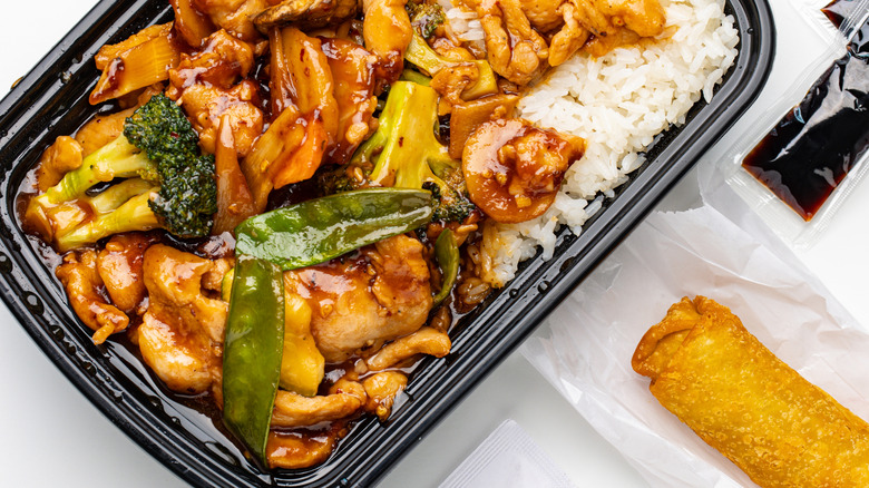 A container of Asian-inspired takeout with spring roll