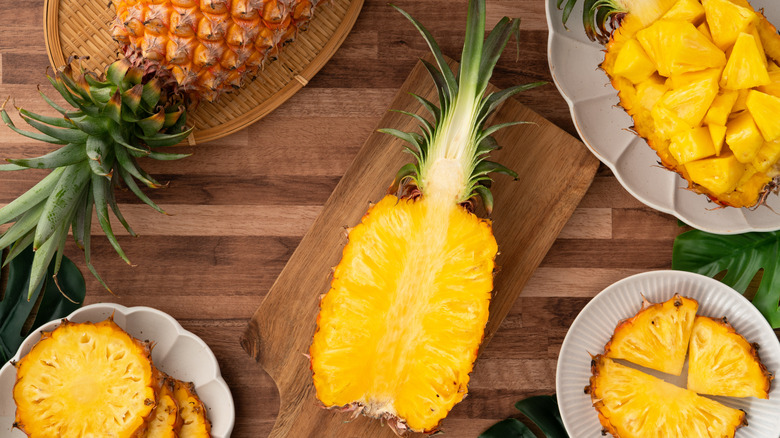 Pineapple chopped, sliced, and cut in half on a table