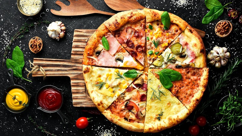Whole cooked pizza with different toppings on each slice