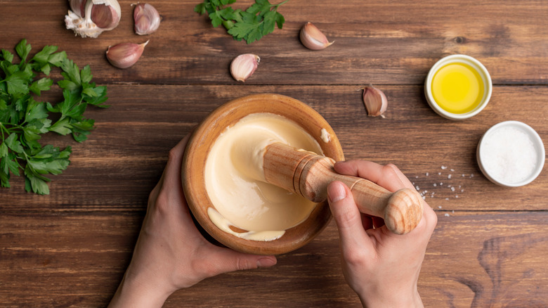 Making aioli sauce with garlic