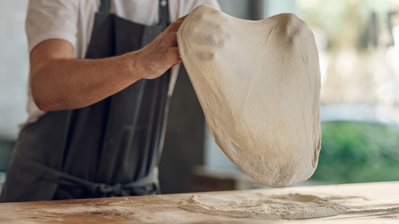 Stretching pizza dough by hand