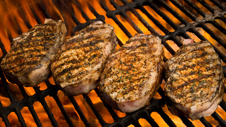 Pork chops cooking on a hot grill