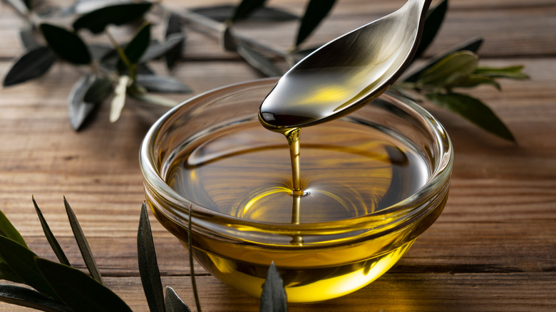 olive oil spooned into a clear bowl