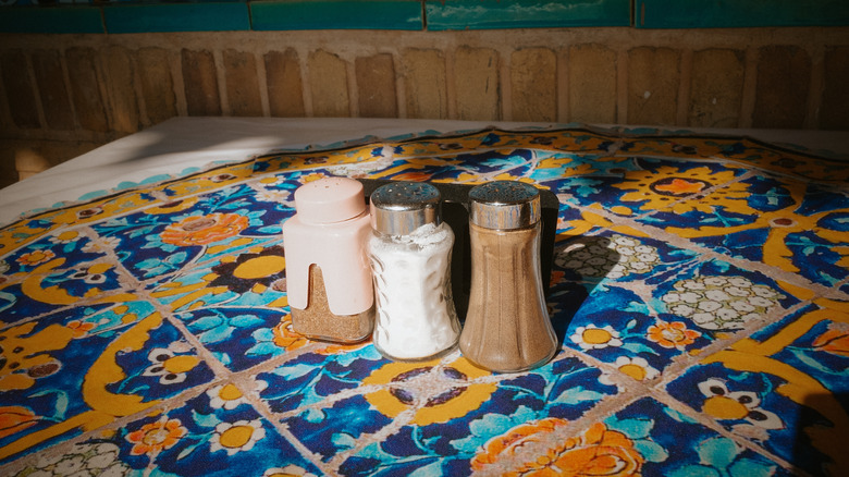 A table with three spice shakers.