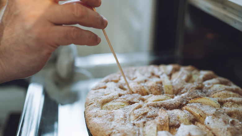 Checking the readiness of a cake with a bamboo skewer