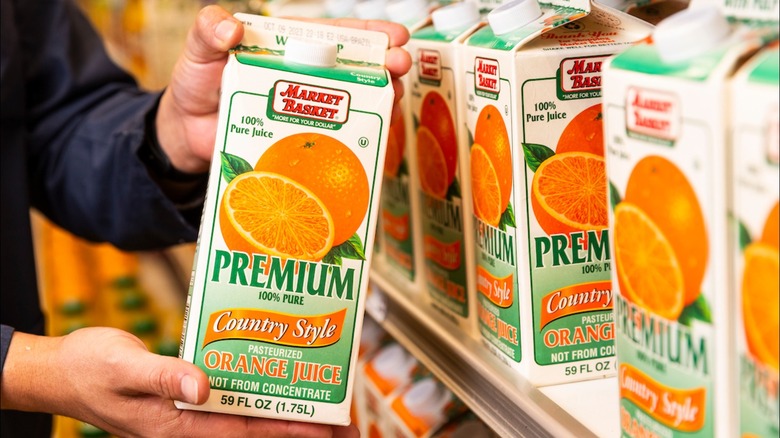 Person holding Market Basket orange juice