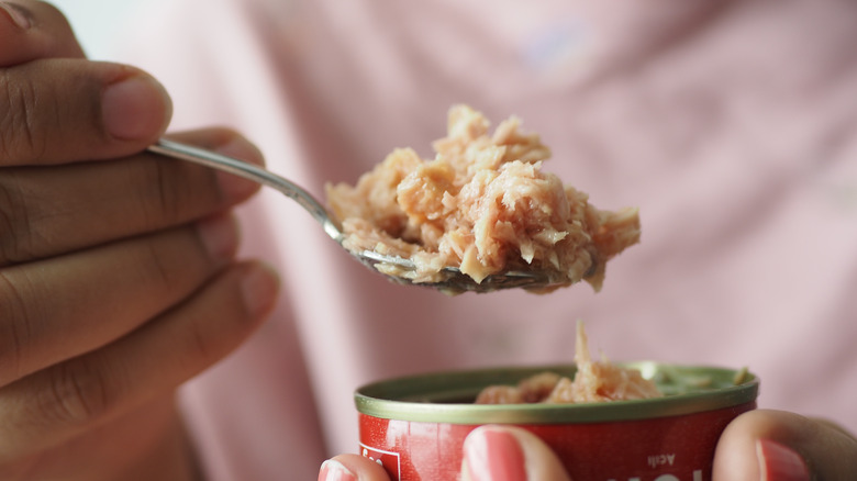 person eating tuna from can