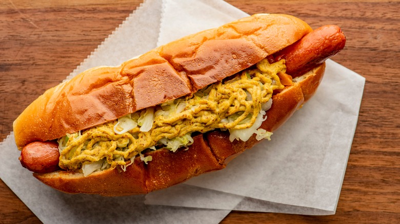 Hot dog in bun with mustard and sauerkraut